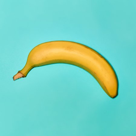 Single banana against blue backgroundの写真素材