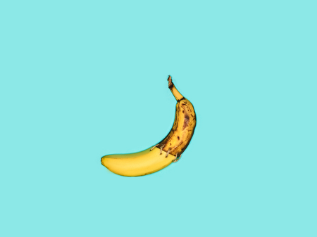 Single banana against blue backgroundの写真素材