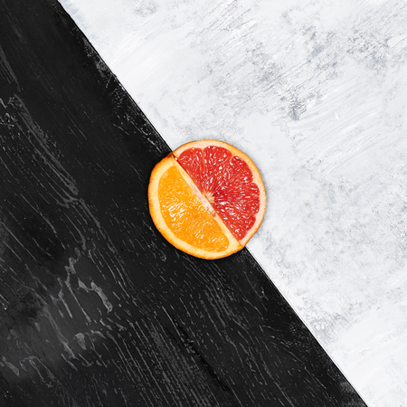Grapefruit and orange citrus fruit halves on woodenの写真素材