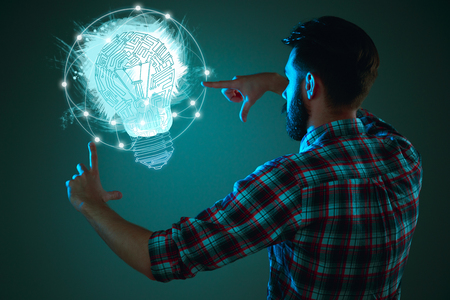 Handsome young man with idea bulb on blueの写真素材