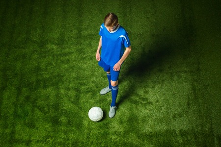 Young boy with soccer ball doing flying kickの写真素材