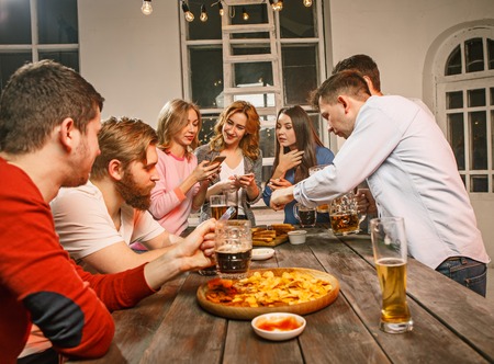 Group of friends enjoying evening drinks with beerの写真素材