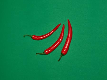 bitter chili pepper and paprika on a green backgroundの写真素材