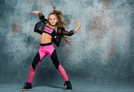 Young girl break dancing on wall background.の写真素材