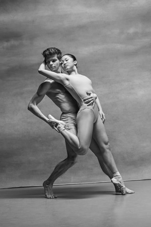Couple of ballet dancers posing over gray backgroundの写真素材