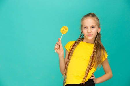 The teen girl with colorful lollipop on a blue background