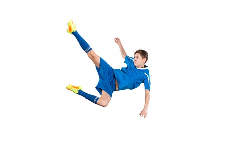 Young boy with soccer ball doing flying kickの写真素材