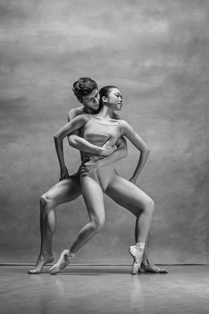 Couple of ballet dancers posing over gray backgroundの写真素材