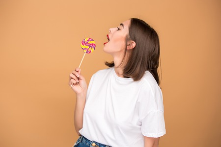 The young woman with colorful lollipop