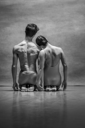Couple of ballet dancers posing over gray backgroundの写真素材
