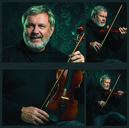 Senior musician playing a violin with wand on black background