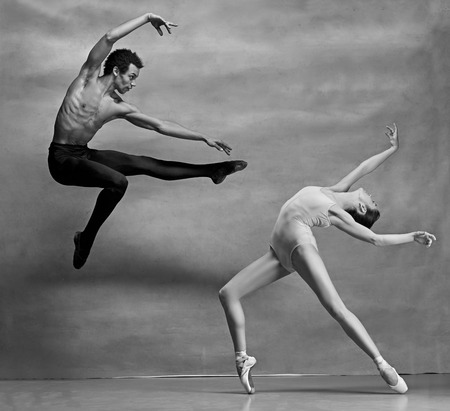 Couple of ballet dancers posing over gray backgroundの写真素材