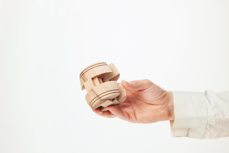 Mans hands holding wooden puzzle.の写真素材