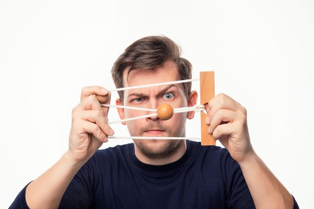 Attractive 25 year old business man looking confused at wooden puzzle.の写真素材