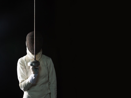 The portrait of woman wearing white fencing costume on blackの写真素材