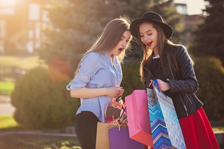 Two girls walking with shopping on city streetsの写真素材