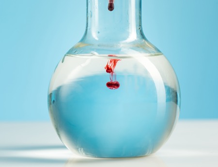 The laboratory glassware and red liquid inside on whiteの写真素材