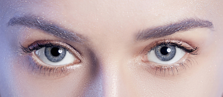 Beautiful woman face portrait close up on blueの写真素材