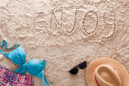 The word Enjoy written in a sandy tropical beachの写真素材
