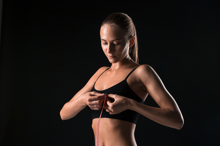 The fit woman measuring perfect shape of beautiful body. Healthy lifestyles conceptの写真素材
