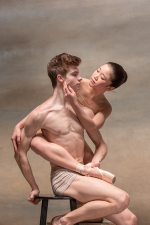 Couple of ballet dancers posing over gray backgroundの写真素材