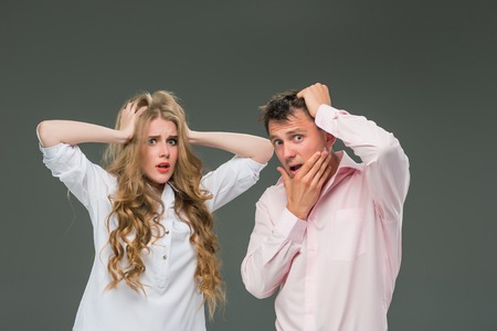 Portrait of a young couple standing against gray background
