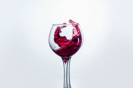Two wine glasses in toasting gesture with big splashing.の写真素材