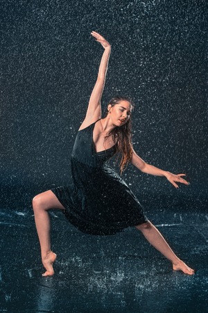 The young beautiful modern dancer dancing under water dropsの写真素材