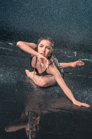 The young beautiful modern dancer dancing under water dropsの写真素材