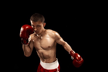 Male boxer boxing with dramatic edgy lighting in a dark studio