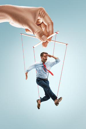 Businessman puppet on gray backgroundの写真素材