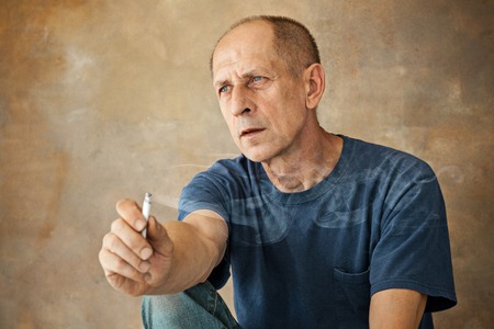 Worried mature man sitting at studioの写真素材