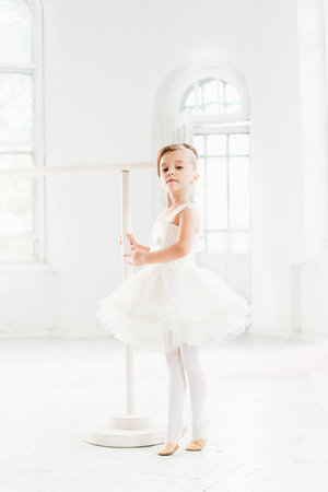 Little ballerina girl in a tutu. Adorable child dancing classical ballet in a white studio.の写真素材