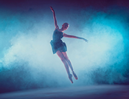 Beautiful young ballet dancer jumping on a lilac background.の写真素材