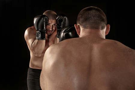 Two muscular men fighting, bodybuilders punching each other, training in martial arts, boxing, jiu jitsuの写真素材