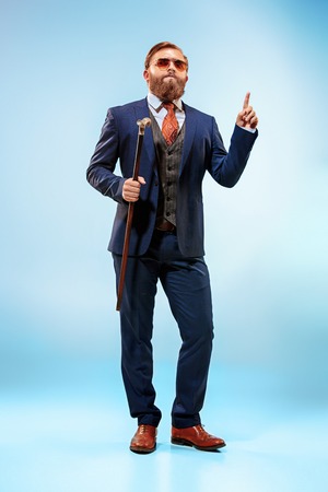 The barded man in a suit holding cane.の写真素材