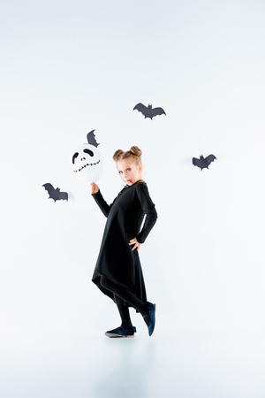 Little girl witch in black dress over magical accessories. Halloween, the studio evening.の写真素材