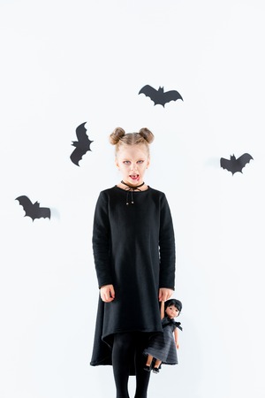 Little girl witch in black dress over magical accessories. Halloween, the studio evening.の写真素材