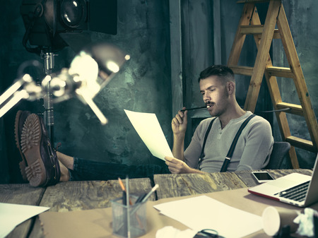 Portrait of a bearded businessman who is working with his notebook at loft studio.