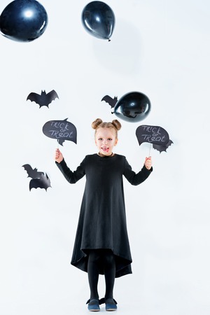 Little girl witch in black dress over magical accessories. Halloween, the studio evening.の写真素材