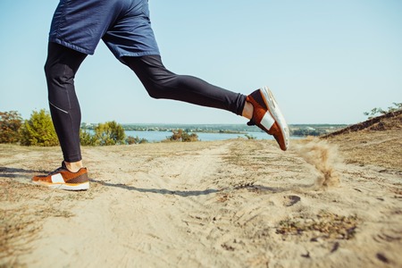 Running sport. Man runner sprinting outdoor in scenic nature. Fit muscular male athlete training trail running for marathon run.の写真素材