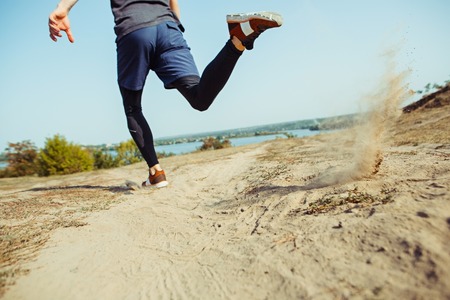 Running sport. Man runner sprinting outdoor in scenic nature. Fit muscular male athlete training trail running for marathon run.の写真素材