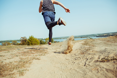 Running sport. Man runner sprinting outdoor in scenic nature. Fit muscular male athlete training trail running for marathon run.の写真素材
