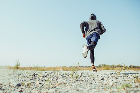 Running sport. Man runner sprinting outdoor in scenic nature. Fit muscular male athlete training trail running for marathon run.の写真素材