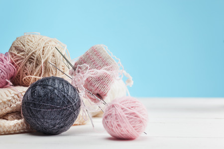 The balls of wool on white wooden background