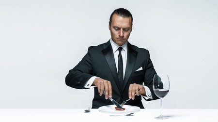 Bloody Halloween theme: crazy man with a knife, fork and meatの写真素材