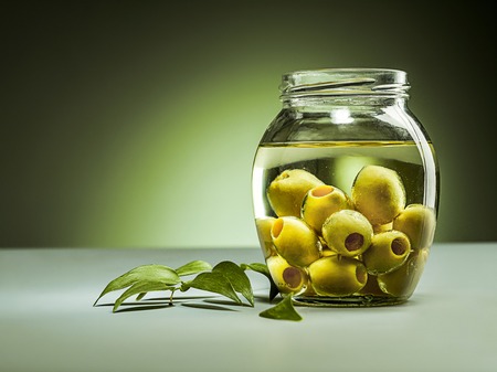 Olive oil and olive branch on the wooden tableの写真素材
