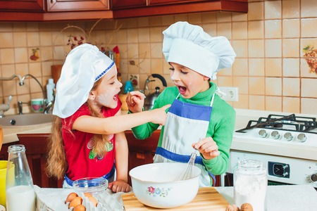 happy family funny kids are preparing the dough, bake cookies in the kitchenの写真素材