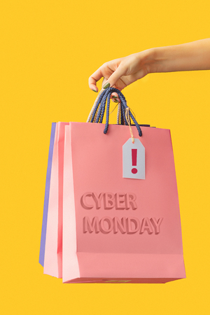 Female hand holding bright shopping bagsの写真素材