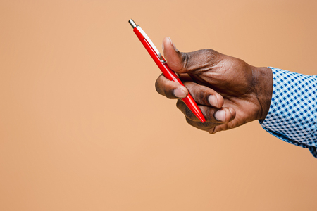 Male hand holding pencil, isolatedの写真素材